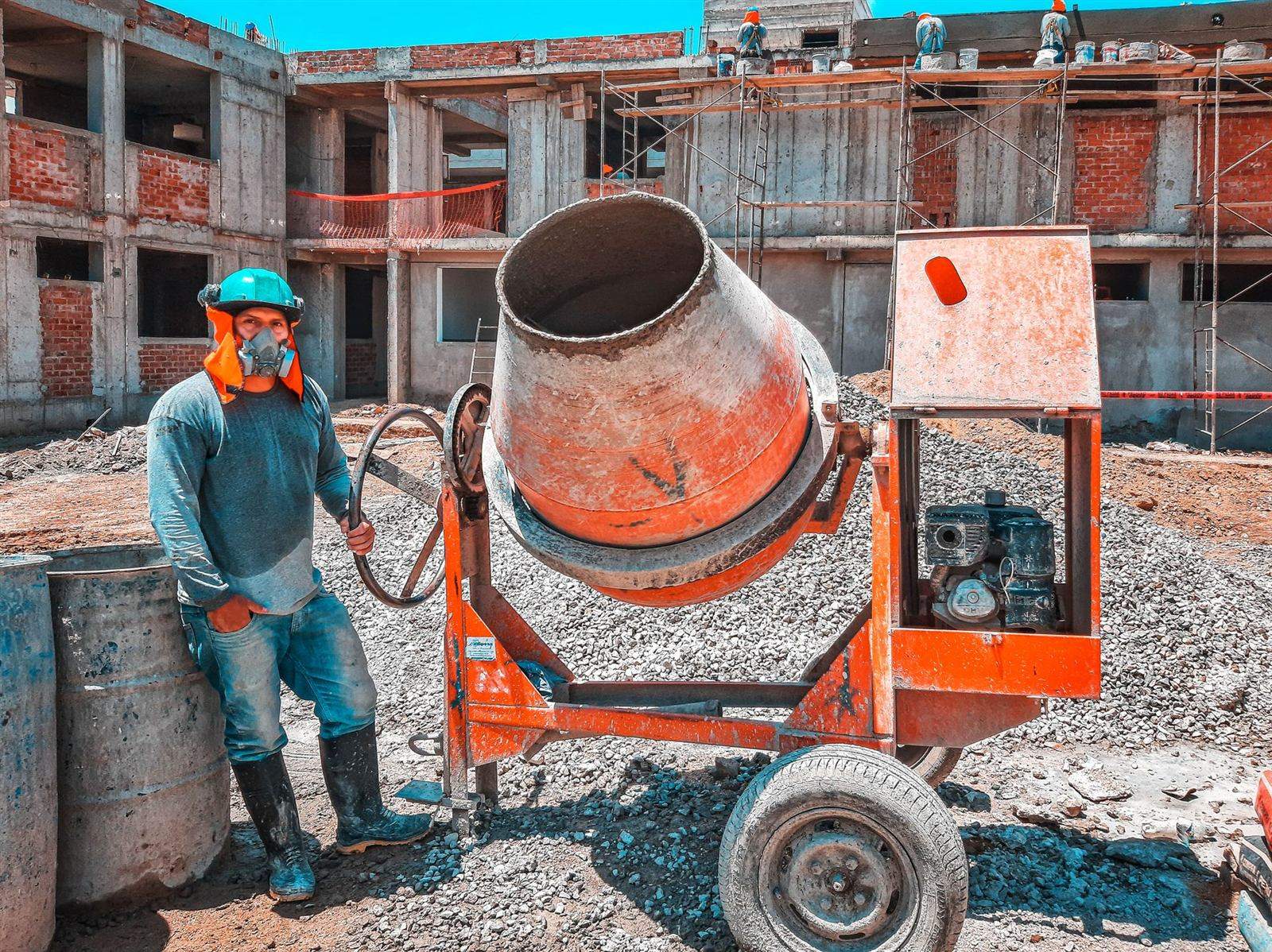 Construction worker with a cement mixer on a building site